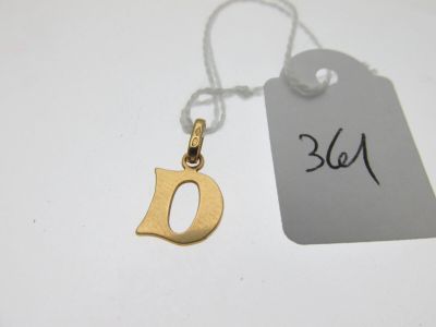 un gros plan d'une étiquette sur laquelle figure un petit « d » doré