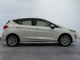 the white car is parked on the concrete floor in the room