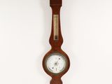 clock hanging on the wall in a room with a white wall