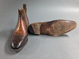 pair of men ' s brown leather shoes on a gray surface