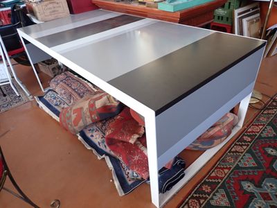 a white table with a black top in a room
