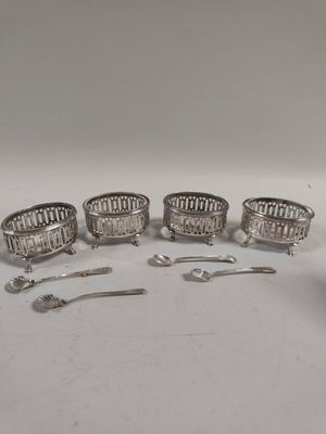 quatre assiettes et cuillères plaquées argent sur un fond blanc