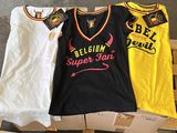 three women ' s t - shirts sitting on a pallet in front of boxes