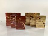 a group of three boxes of opium perfume sitting on top of a table