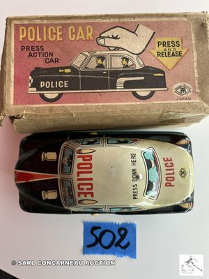 une petite voiture de police miniature et une boîte posées sur une table