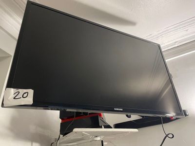 a flat screen tv hanging on a wall in a room