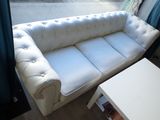 a white couch sitting in front of a window next to a coffee table