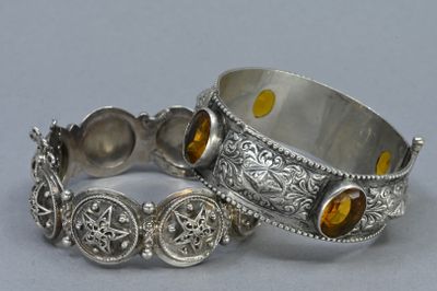 pair of silver bracelets with citrine stones on them