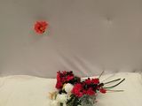 un bouquet de fleurs rouges et blanches posé sur un lit