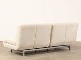 an image of a white couch sitting on top of a cement floor
