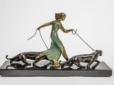 bronze statue of a woman walking a dog with two dogs on a leash