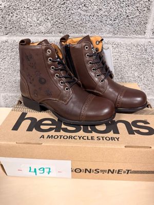 brown leather boots with brown laces are on top of a cardboard box