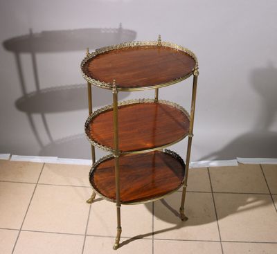 a three tiered table that is on a tile floor