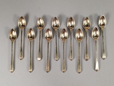 six cuillères en argent sont alignées sur une table