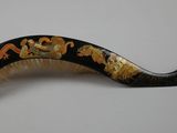 a black and gold hair comb with gold flowers on it