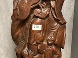 a wooden statue of a man sitting on a table