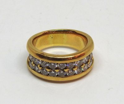 bague en or jaune sertie de diamants blancs sur un fond blanc