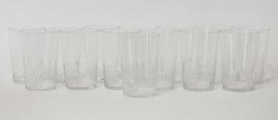 six clear glasses lined up in a row on a white surface