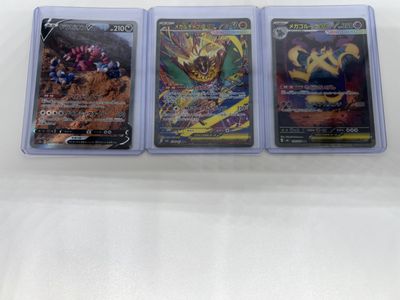 three different pokemon cards sitting on top of each other on a table