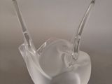 a clear glass bowl with two spoons sitting on top of it