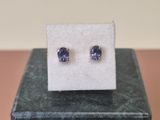 une paire de boucles d'oreilles en saphir bleu posées sur un bloc de marbre