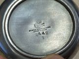 a person holding a silver plate that has a logo on it