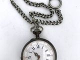 a silver pocket watch on a chain with a chain around it