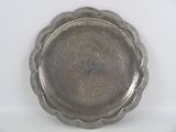 a silver plate with a design on it on a white surface