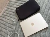 un ordinateur portable et un chargeur posés par terre à côté d'un téléphone portable