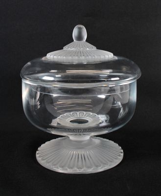 un récipient en verre transparent muni d'un couvercle, posé sur une surface noire