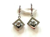 une paire de boucles d'oreilles en argent et cristal sur fond blanc