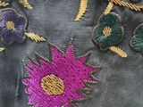 embroidery on a jacket with flowers and leaves on it