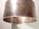 a close up of a silver bracelet on a stand