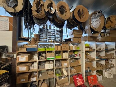 a room with a lot of boxes and wires on the shelves