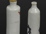 two white vases sitting on top of a table next to each other