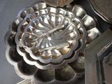 a silver plate with a flower on it on a table next to other silver dishes