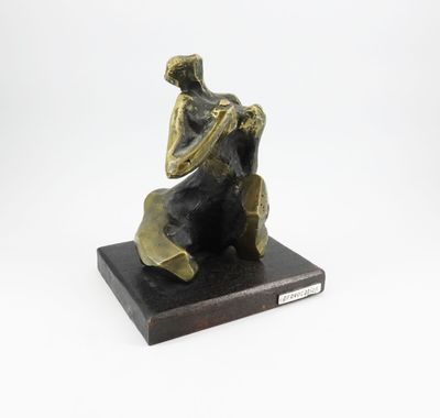 une statue en bronze d'une femme assise sur un rocher