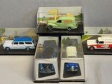four different model cars are in a display case on a table