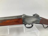 a rifle with a wooden barrel and a metal handle