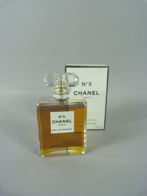Flacon et coffret du parfum Chanel n° 5 posés sur une surface blanche