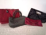 three purses sitting on a bed next to each other