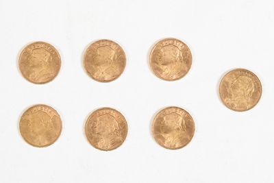 plusieurs pièces d'or sont disposées en cercle sur une surface blanche