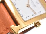 a close up of a gold watch with a brown strap