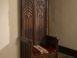 un banc en bois sur lequel est posé un coussin rouge, dans une pièce