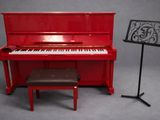 un piano rouge posé à côté d'un pupitre