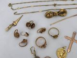 lot of gold and silver jewelry including a cross, a ring, a necklace, a brooch, and a cross