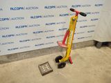 a red and yellow scooter sitting next to a wall