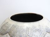 a white vase with a design on it sitting on a table
