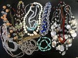 a lot of necklaces and bracelets on a table