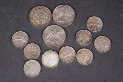 Plusieurs pièces de monnaie différentes sont disposées en cercle sur une surface noire